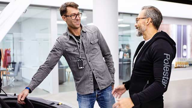 Verkaufsberater von Polestar neben einem Auto
