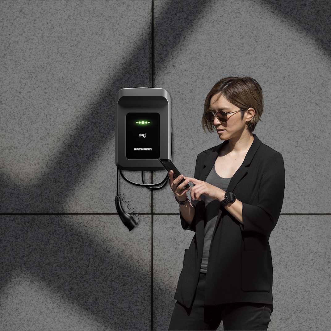 Frau nutzt App zur Steuerung ihrer Wallbox