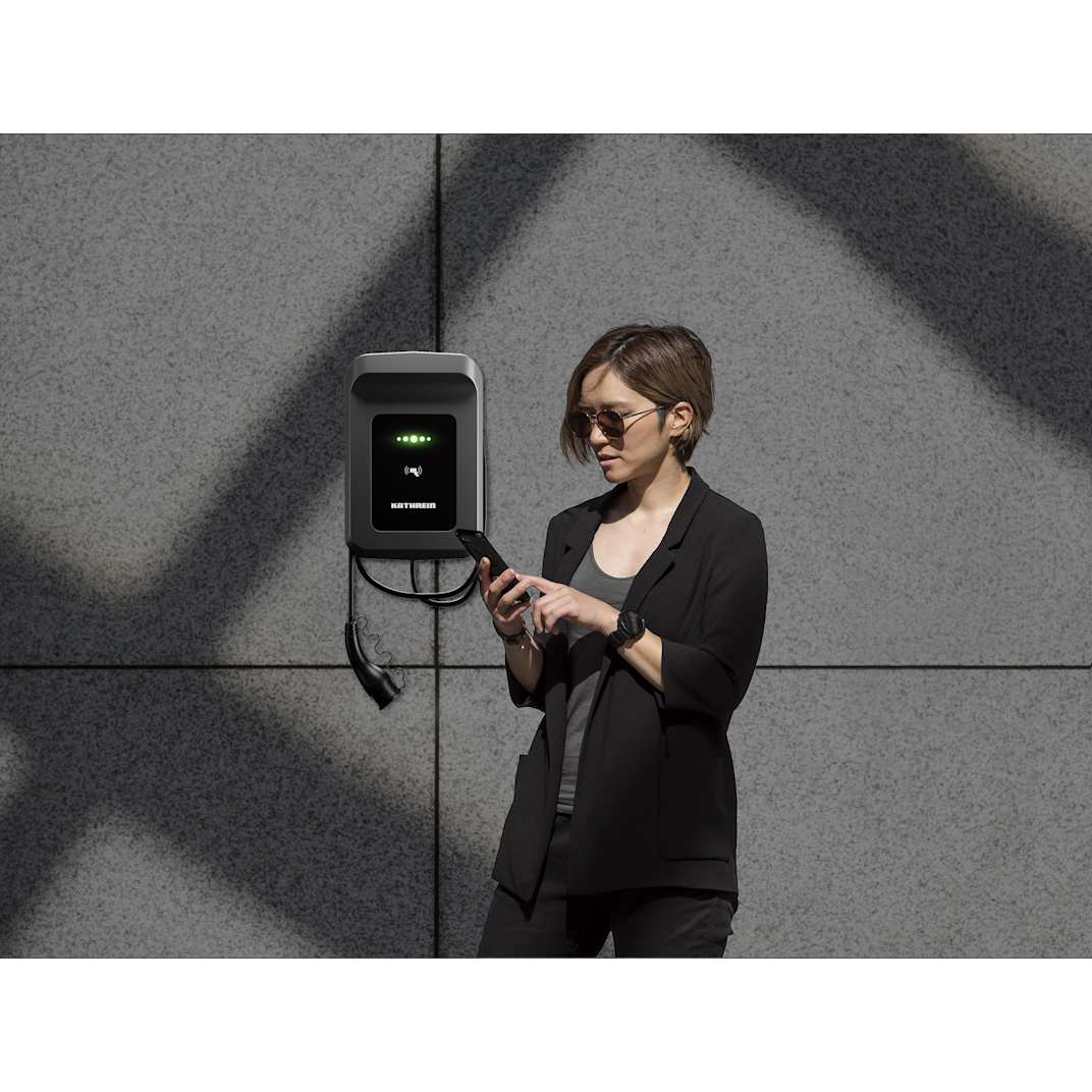 Frau nutzt App zur Steuerung ihrer Wallbox