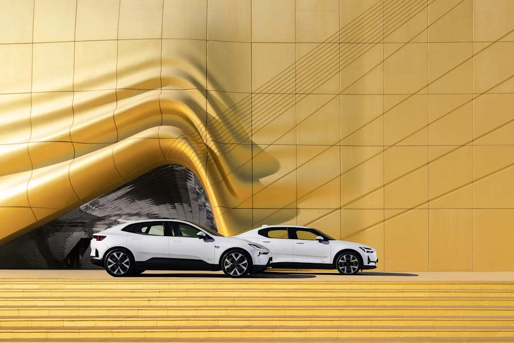 Polestar 4 und Polestar 2 vor gelbem Hintergrund