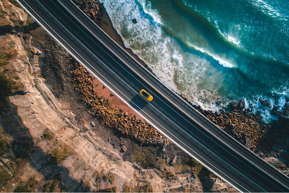 gelbes Auto auf STraße am Meer