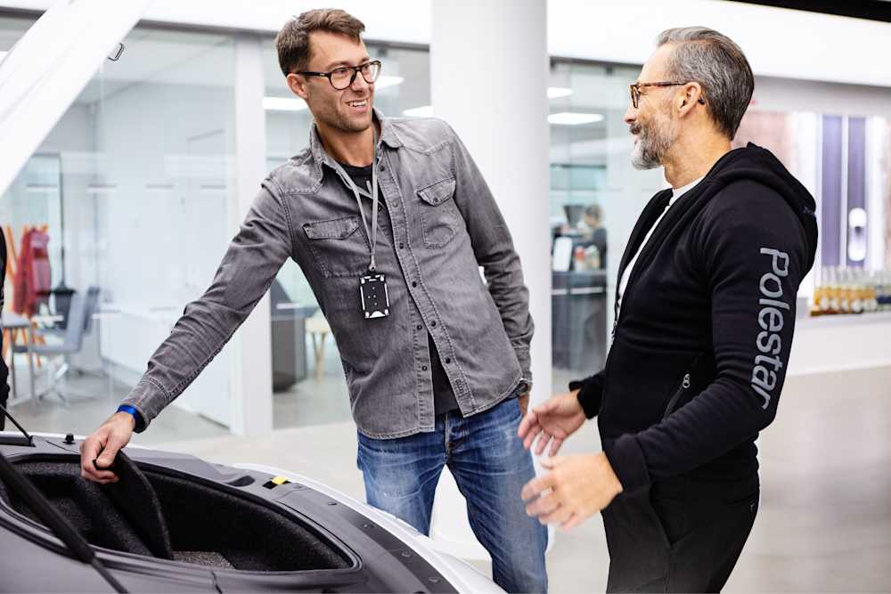 Verkaufsberater von Polestar neben einem Auto