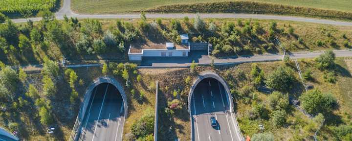 Bild von ein- und ausfahrenden Autos in einen Tunnel, der zu den mautpflichtigen Autobahnabschnitten in der Schweiz gehört