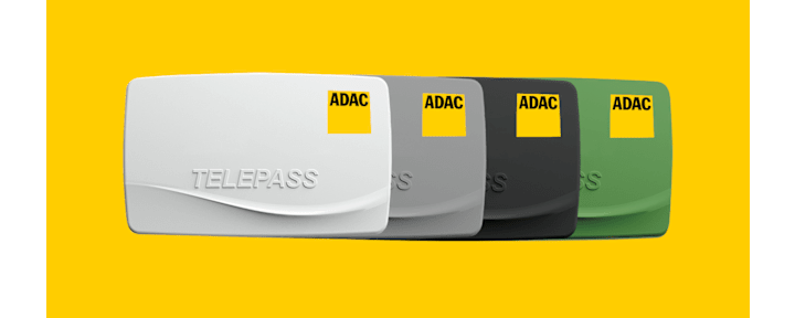 Die ADAC Mautbox Premium in den Farben weiß, grau, schwarz und grün auf gelbem Hintergrund