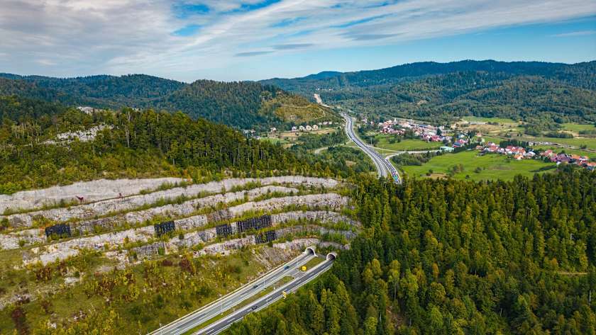 Luftaufnahme einer kroatischen Autobahn, die sich durch bewaldete Hügel und Ortschaften schlängelt – geeignet für Informationen zur Nutzung der ADAC Mautbox in Kroatien
