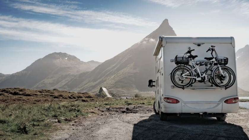 Wohnmobil mit Fahrradanhänger vor Berglandschaft