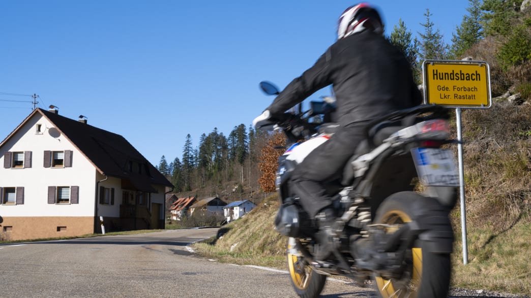 Motorradfährer fährt auf Straße am Ortseingang zu Hundsbach