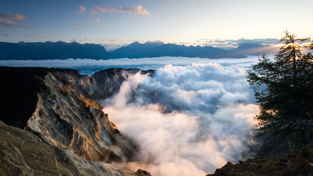 Blick von Bergen ins Wolken-verhangene Tal
