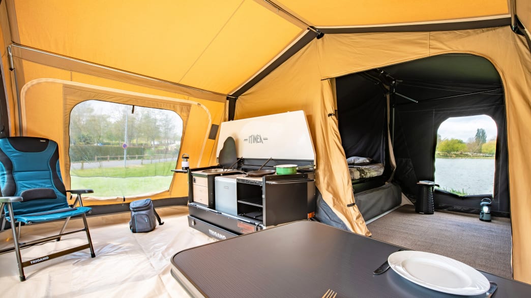 Das gelbe Trigano Itinea Anhaenger Zelt mit Boden Küche, Tisch und Schlafplätzen