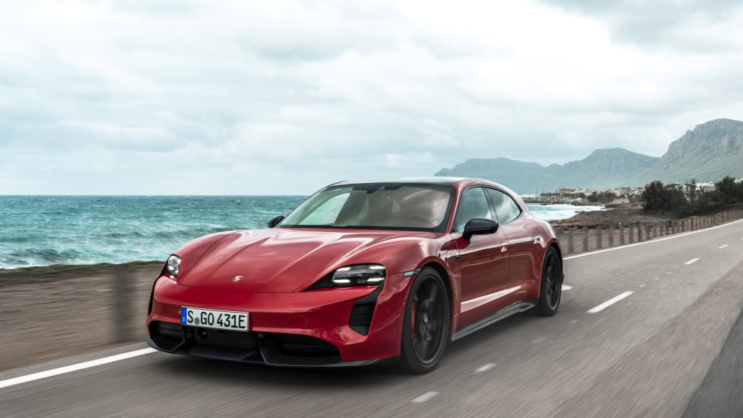 Der neue rote Porsche Taycan GTS Sport Turismo von schräg vorne fährt an der Küste Mallorcas