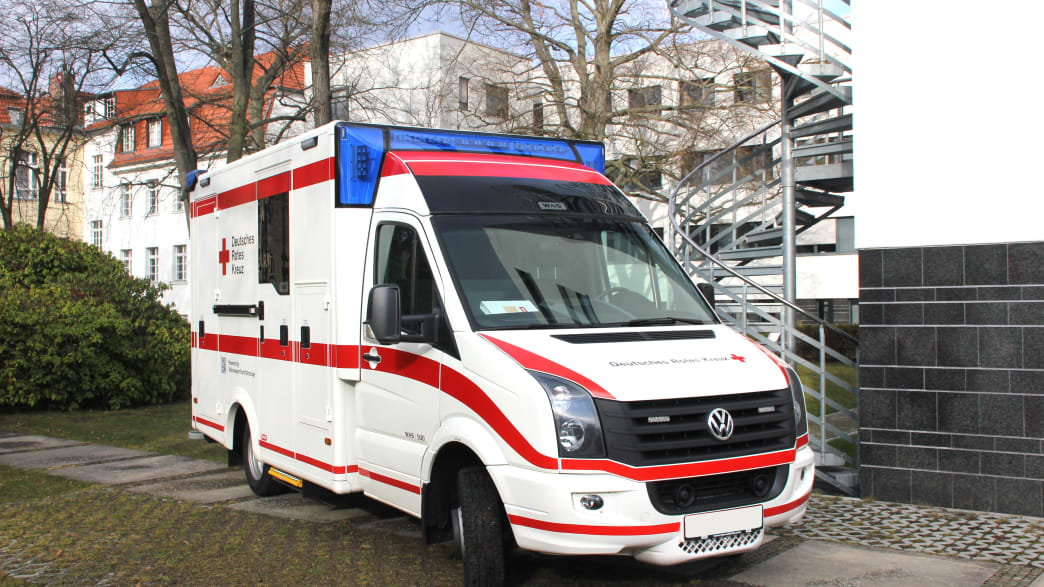 Ein Rettungswagen des Deutschen Roten Kreuzes steht in einer Wohnsiedlung
