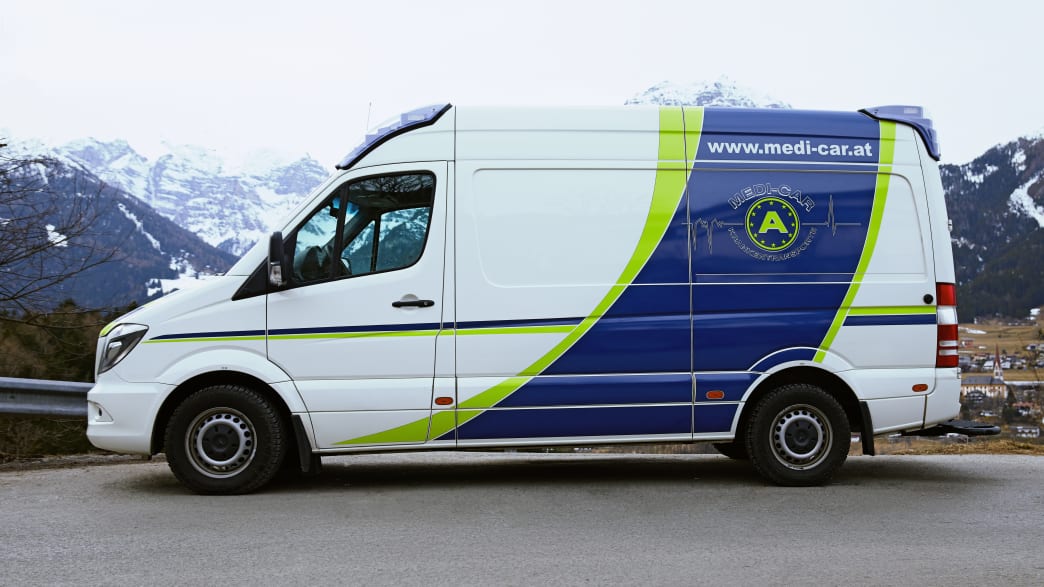 Ein Rettungswagen der Medicar Krankentransport GmbH in Österreich vor Bergkullise
