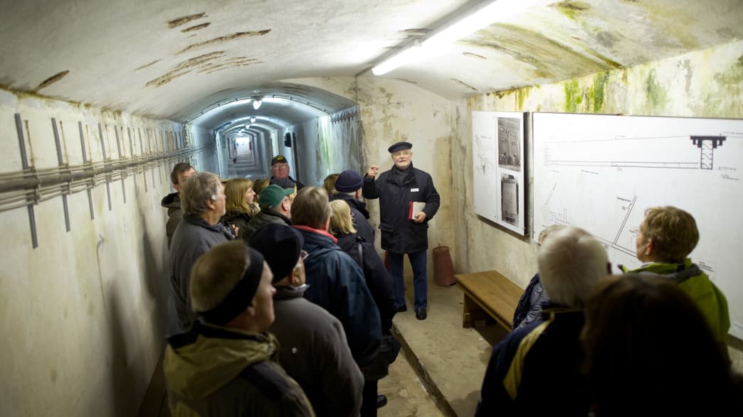 Menschen während einer Führung in einem Bunker auf Helgoland