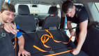 Mitarbeiter befestigen Spanngurte in Vorbereitung für den Crashtest Gepäcksicherung