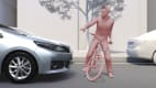 silberner Toyota RAV 4 bremst vor einem Fahrradfahrer