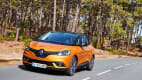 Ein orangener Renault Scenic Minivan fährt auf der Landstrasse