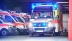 Ein Rettungswagen der Johanniter startet seine Fahrt mit Blaulicht aus einer Fahrzeughalle
