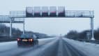 Auto fährt auf verschneiter Autobahn