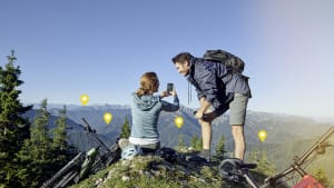Mann und Frau nutzen Smartphone auf Berggipfel
