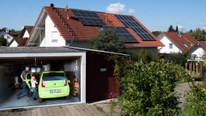 Solarpaneelen auf dem Dach eines Einfamilienhauses erzeugt den Strom zum Laden des E-Autos
