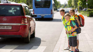 Schulkinder mit Warnweste auf dem Weg in die Schule