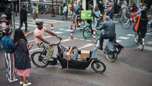Handwerker fährt mit einem E-Lastenrad durch die Stadt