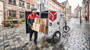 Paketzusteller liefert Pakete mit Lastenrad aus