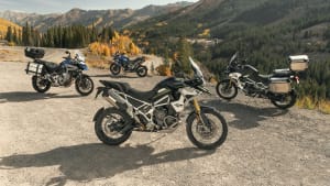 4 Motorräder der neuen Produktfamilie der Tiger 1200 stehen vor einer sonnigen Bergkulisse