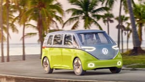 VW ID Buzz fährt auf einer mit Palmen gesäumten Strasse