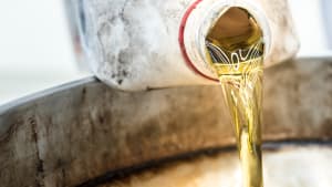 Altöl wird von Kanistern in Ölwanne gegossen