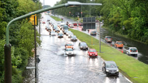 Autos fahren auf einer nach einem Unwetter überschwemmten Straße in Berlin