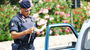 Italienischer Polizist kontrolliert Papiere eines Autofahrers