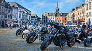 Viele Motorräder stehen auf einem Platz in einer Stadt