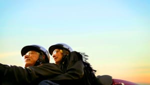 Ein Paar fährt mit Helm und Brille Motorrad