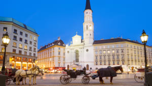 Historische Altstadt Wien am Michaelerplatz in der Dämmerung mit Laternen und Pferdekutschen
