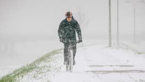 Fahrradfahrer fährt auf einem verschneiten Radweg