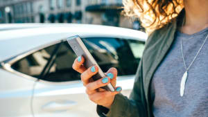 Frau nutzt Remote App um ihr Auto zu öffnen