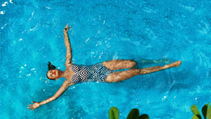 Eine Frau erholt isch im Pool beim schwimmen