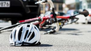 Fahrrad und Fahrradhelm liegen nach einem Unfall auf der Straße