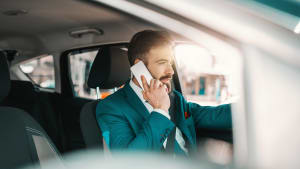 Geschäftsmann telefoniert während der Autofahrt