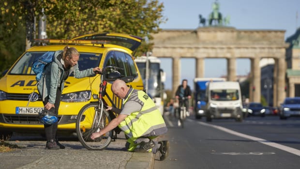 ADAC Pannenhelfer hilft einer Frau mit Fahrradpanne