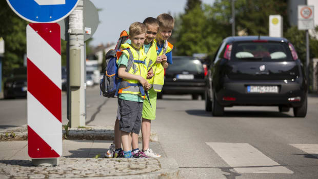 Kinder überqueren Zebrastreifen auf ihrem Schulweg