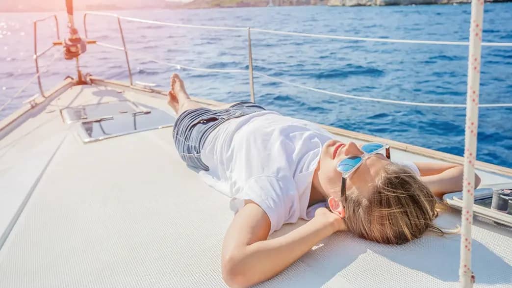 Junge Frau entspannt auf Segelschiff