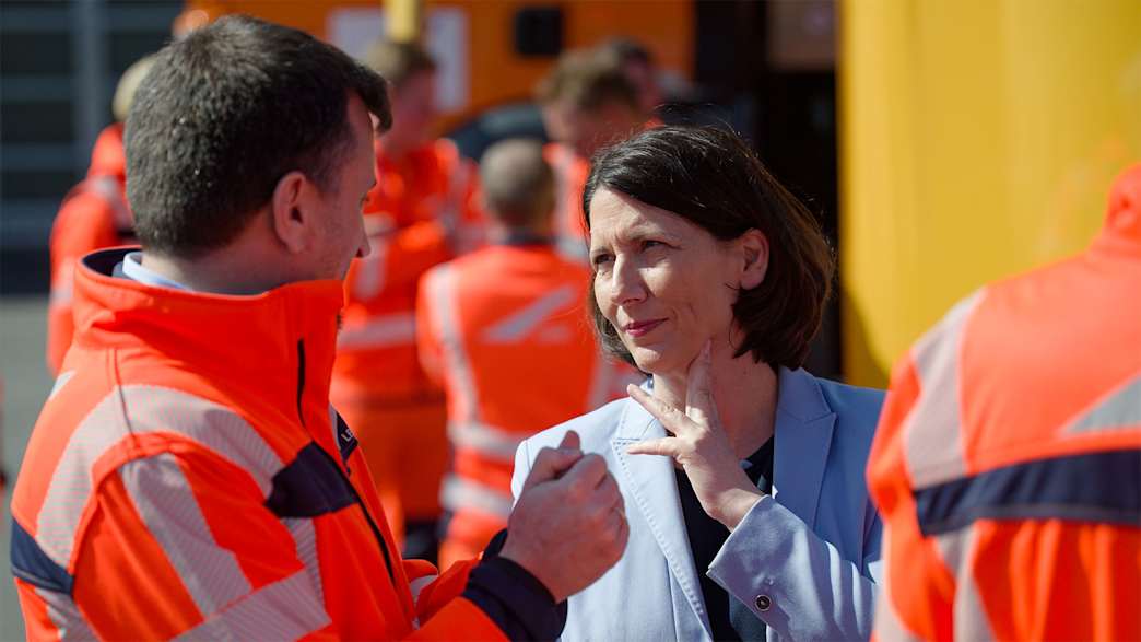 Ministerin Daniela Schmitt im Gespräch mit einem Straßenwärter.