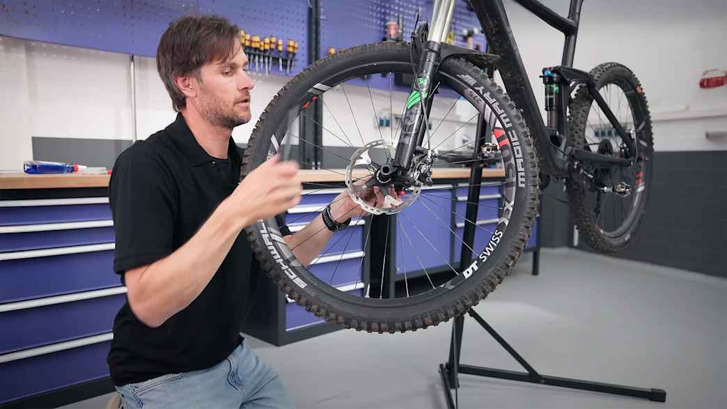 ADAC Mitarbeiter Matthias Zimmermann wechselt die Bremsbeläge am Fahrrad