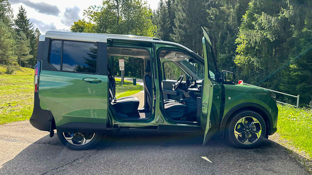 Seitenansicht des Ford Tourneo E-Courier mit geöffneten Türen, geparkt auf einer Straße.