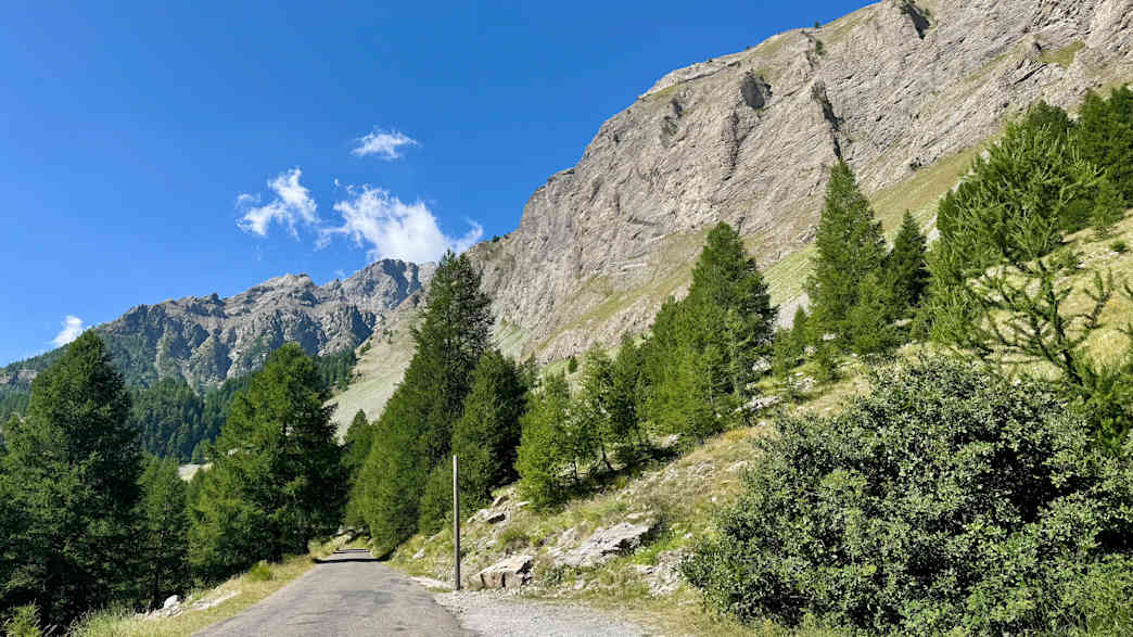 Bergstraße am Col de la Cayolle mit steilen Felsformationen und klar blauem Himmel in den Französischen Alpen.
