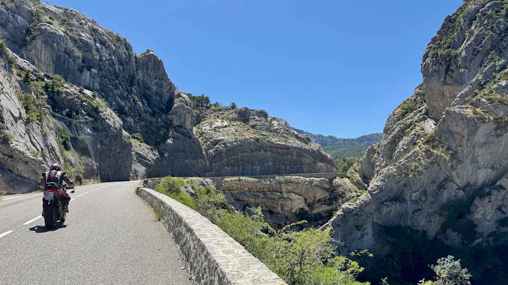 Motorradfahrer am Col de Lèques, kurvige Alpenstraße mit Felslandschaft