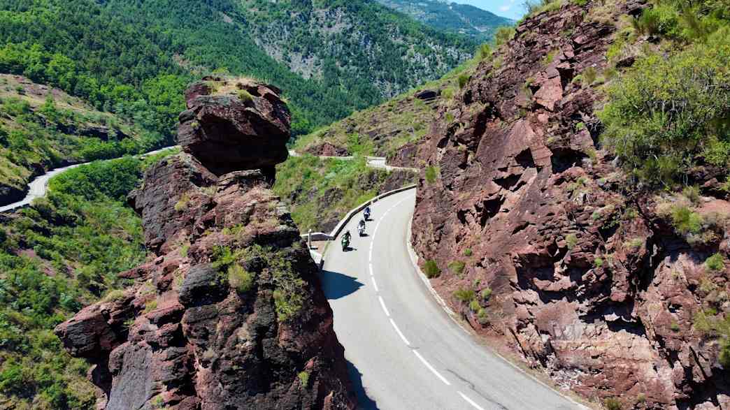Motorräder fahren entlang der roten Felsformationen der Gorges de Daluis in den französischen Seealpen.