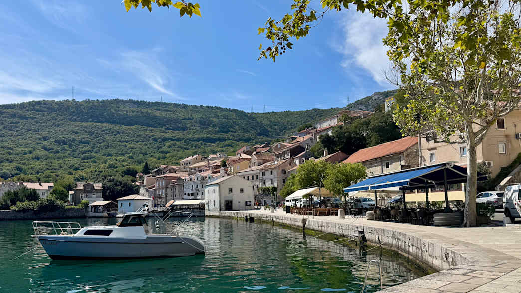 Blick auf die Küstenstadt Bakar in Kroatien mit Hafen und Bergen.